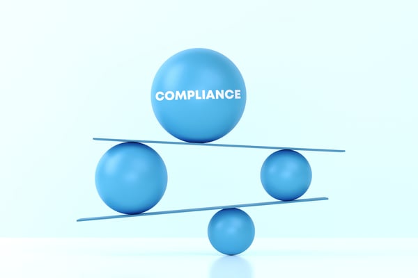 balls balanced on rulers, one with the word compliance