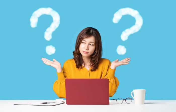 woman at computer with question marks on either side