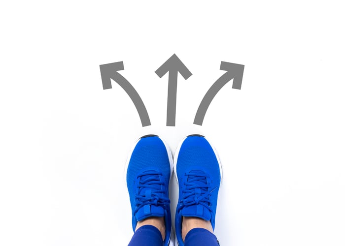 bright tennis shoes with arrows representing three different choices of path