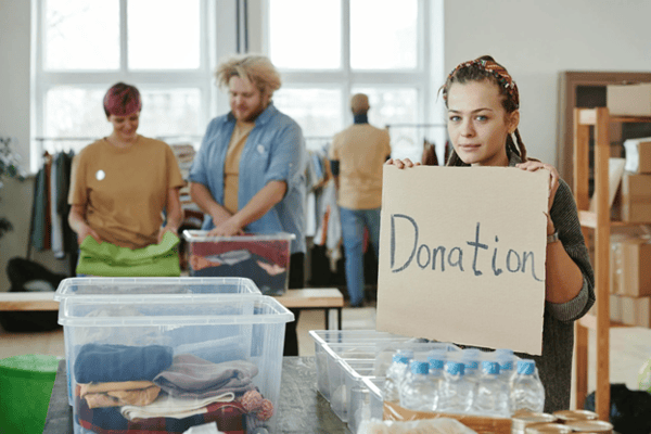 woman holding donation sign at community donation event