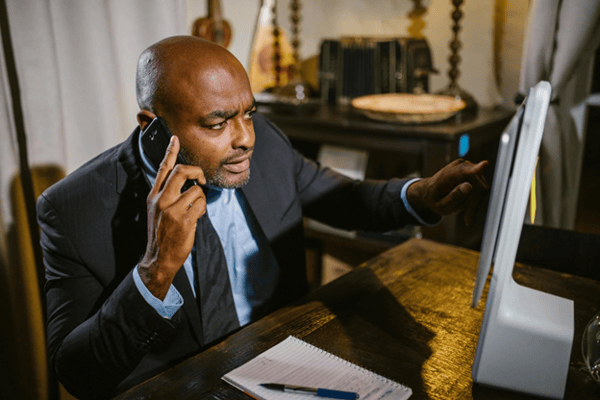 man talking on the phone while looking at the screen 