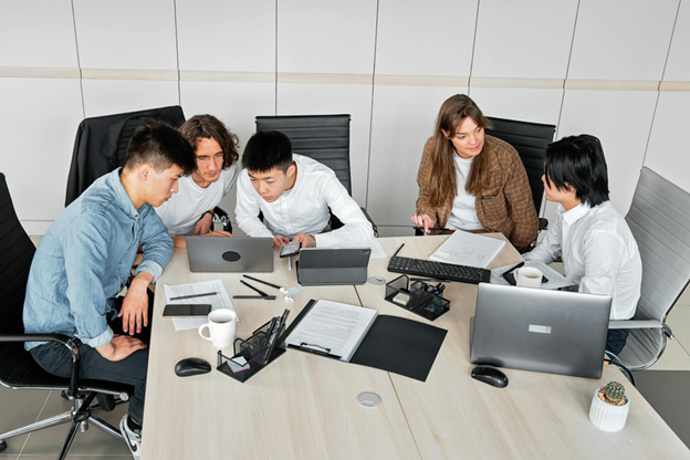 young professionals collaborating at a table with laptops